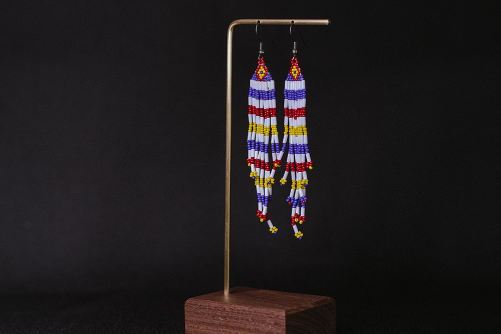 Hand-made earrings with white, red, yellow, and blue beads.